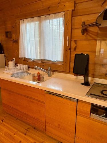 a kitchen with a sink and a window at SAUNA Log Cabin オーガスタハウス君津 in Kimitsu