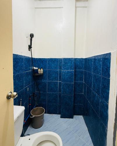 a blue tiled bathroom with a toilet and a shower at AisG Homestay Tres -Fully Furnished Shared Homestay FREE NETFLIX-3mins to Airport in Puerto Princesa City