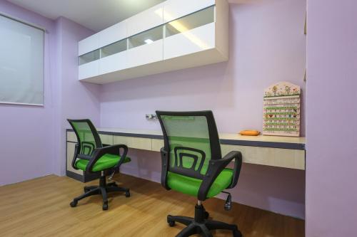 two green chairs in a waiting room with a counter at Spacious 12 pax Landed Homestay By NexxField in Ampang