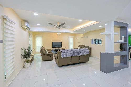 a living room with a ceiling fan and a couch at Spacious 12 pax Landed Homestay By NexxField in Ampang