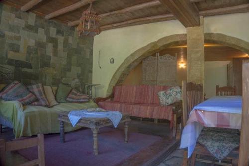 a living room with a couch and a table at Diving into silence - Traditional Stone House in Kakópetros