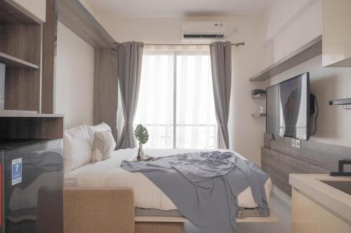 ein Schlafzimmer mit einem Tisch vor einem Fenster in der Unterkunft Best Choice and Cozy Studio Sky House BSD Apartment By Travelio in Tangerang