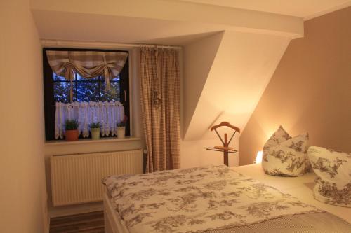 a bedroom with a bed and a window with flowers at Romantik Landhaus in Dresden