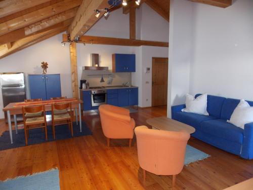 uma sala de estar com um sofá azul e uma mesa em Villa Santer em Dobbiaco