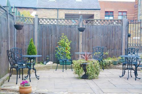 a patio with tables and chairs in front of a fence at Pier View Self Catering Luxury Apartments in Southend-on-Sea