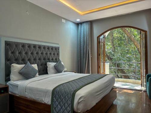 a bedroom with a large bed with a large window at Palm Mystic Inn - Indiranagar in Bengaluru