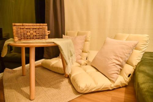 a couch with a table and a chair with pillows at Take Time Nature Resort in Ban Tha Sai