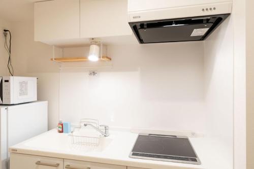 a kitchen with a sink and a stove top oven at High Leaf Shiba Daimon in Tokyo