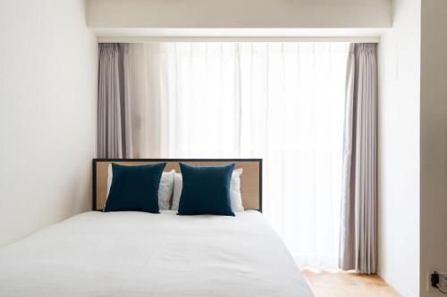 a bedroom with a large bed with blue pillows at High Leaf Shiba Daimon in Tokyo