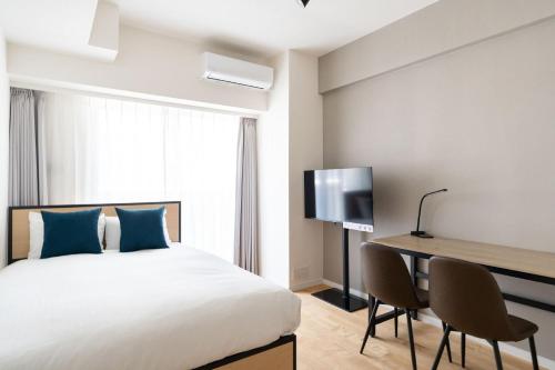 a bedroom with a bed and a desk and a television at High Leaf Shiba Daimon in Tokyo