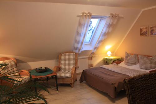 a bedroom with a bed and chairs and a window at Romantik Landhaus in Dresden