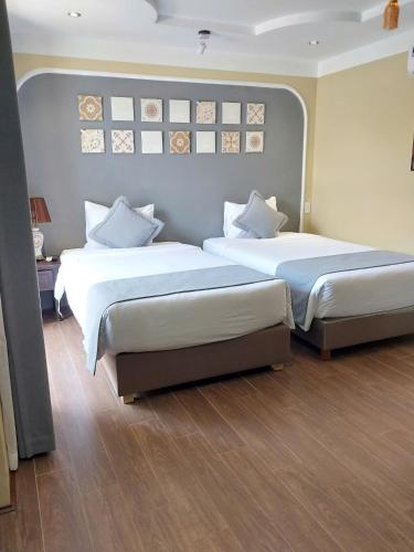 two beds in a hotel room with two beds sidx sidx sidx at Hoianan Boutique Hotel in Hoi An