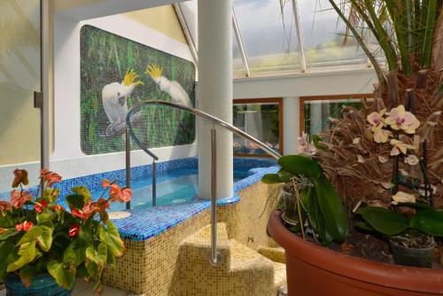 a room with plants and a picture of a bird at Wellness Hotel Kakadu in Keszthely