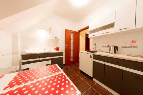 a kitchen with white cabinets and a red and white table at Pokoje Gościnne Przylesie in Łobez