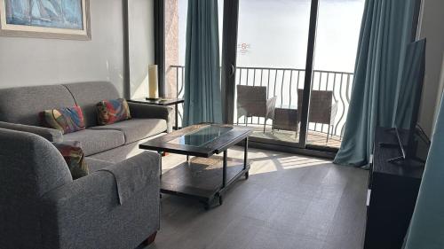 a living room with a couch and a coffee table at Hosteeva 17th Floor Palms Resort Penthouse Oceanfront w Balcony in Myrtle Beach