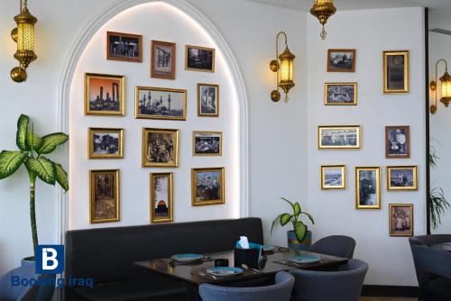 a dining room with a table and pictures on the wall at Andalus Hotel in Baghdad