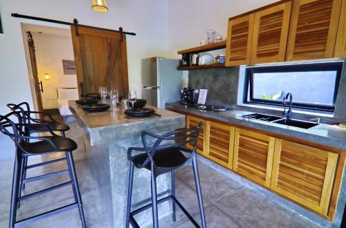 a kitchen with a sink and a counter with stools at Jenna in Koh Phangan