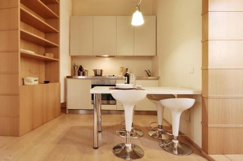 una cucina con tavolo e due sgabelli di Vigna Nuova Suites a Firenze