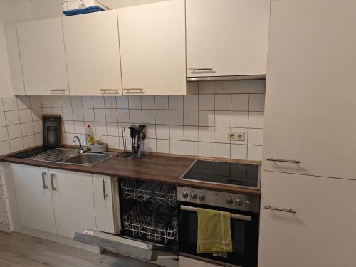 a kitchen with white cabinets and a sink and a stove at IaM 3 Zimmer 90 qm Küche Badezimmer kraftraum 44 u in Plettenberg