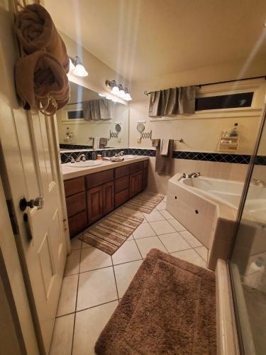 a bathroom with a tub and a sink at Wine Country Oasis Private Pool & Spa in Acampo
