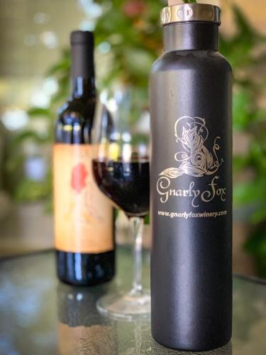 a bottle of wine next to a glass of wine at Wine Country Oasis Private Pool & Spa in Acampo