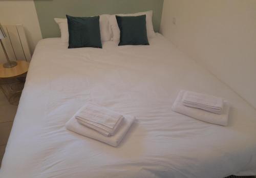 - un grand lit blanc avec 2 serviettes pliées dans l'établissement Studio Cosy 15 m2 au fond du jardin, à Châlons-en-Champagne