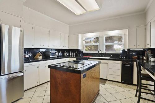 a kitchen with white cabinets and a stainless steel refrigerator at Wine Country Oasis Private Pool & Spa in Acampo