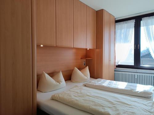a bedroom with a bed with white sheets and a window at 2-Raum FeWo Gipfelglück - Hallenbad & Sauna in Fischen