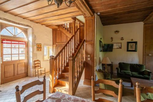 - un salon avec un escalier en bois dans une maison dans l'établissement Manoir de Damigny, à Saint-Martin-des-Entrées