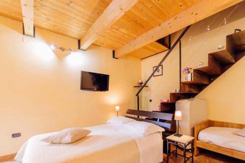 sypialnia z dwoma łóżkami i telewizorem na ścianie w obiekcie B&B La Casa Di Plinio w mieście Pompeje