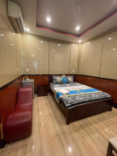 a bedroom with a bed and a chair in it at Khách Sạn Sapphire in Gò Công