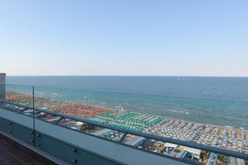 a view of the beach and the ocean from a balcony at Charlie in Pesaro in Pesaro