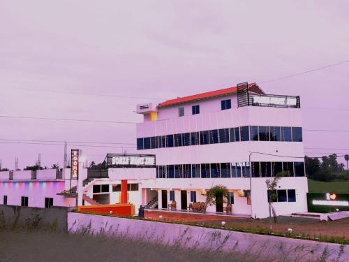 a large white building with a lot of windows at Hotel SONIA MAHI INN KANYAKUMARI in Kanyakumari