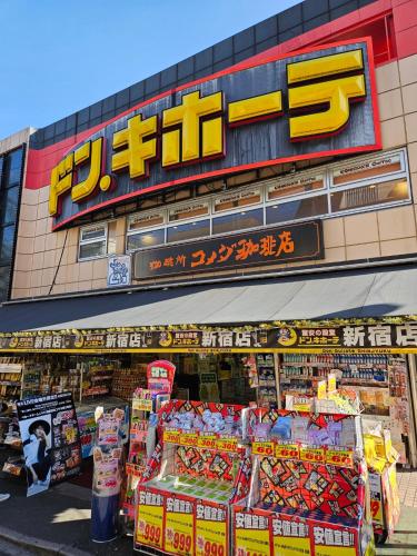 a store with a sign on the side of a building at Shinjuku Harusame Apartment -Twin room- in Tokyo
