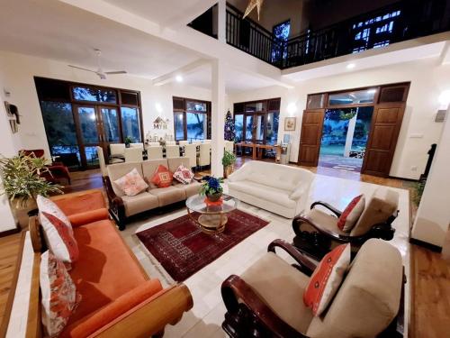 a large living room with couches and a table at MYH - Lake Front Pvt Villa with Staff and Includes FREE Breakfast of your choice in Bandaragama