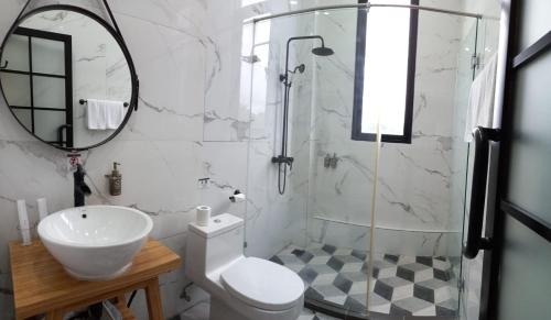 a bathroom with a shower and a toilet and a sink at S Loft Manado in Manado