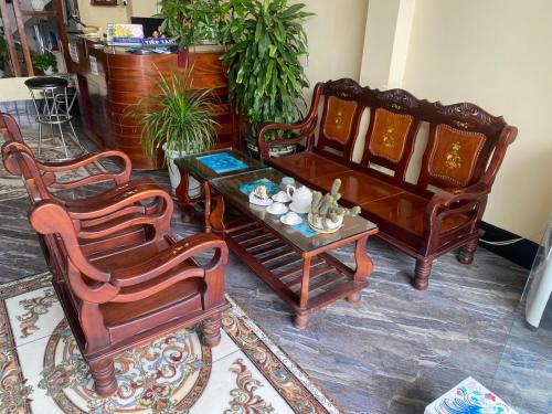 three chairs and a coffee table in a living room at Khách Sạn Sapphire in Gò Công