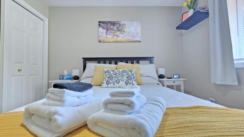 a bedroom with a bed with white blankets and pillows at Family Friendly 3 Bedroom Unit - Close to Downtown Kingston! in Kingston