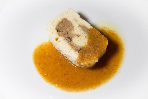 a piece of cake with yellow sauce on a white plate at Hotel Krizman in Monrupino