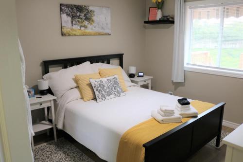 a bedroom with a large white bed with two tables at Family Friendly 3 Bedroom Unit - Close to Downtown Kingston! in Kingston