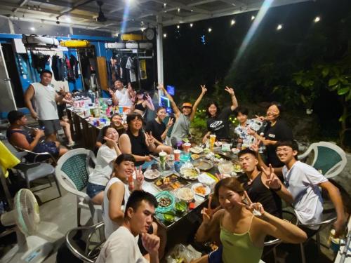 a group of people sitting at a table eating food at 藍貝島潛水背包旅宿一館 Lambay Island Dive Hostel I in Xiaoliuqiu