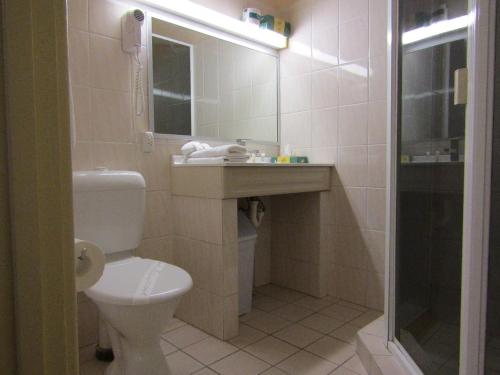a bathroom with a toilet and a sink and a shower at Glenelg Motel in Adelaide