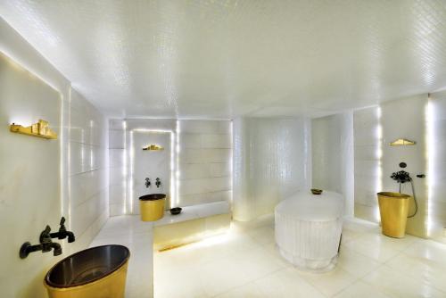 a white bathroom with a tub and a sink at Tiara Thermal & SPA Hotel in Bursa