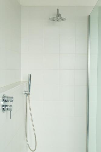 a shower with a shower head in a bathroom at Spacebility Airport - self check-in in Cagliari