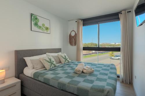 a bedroom with a bed with a blue checked blanket at Luxury Penthouse - Santa Rosalia Lake and Life Resort in Torre-Pacheco