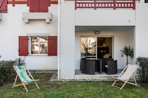 2 chaises dans une cour à côté d'une maison dans l'établissement Hossegor - T2 - Lac - Plage - Couple - Paddle, à Hossegor