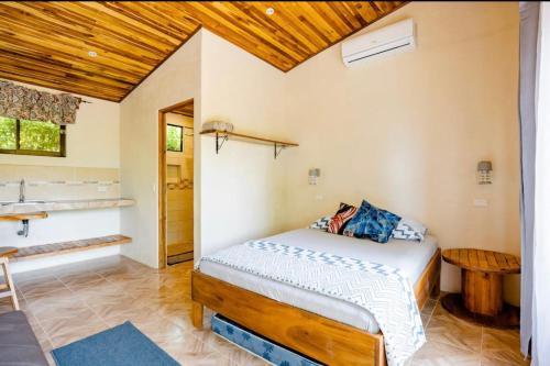 a bedroom with a bed and a wooden ceiling at Apartamento el Guanacaste, cerca Tamarindo con Piscina in Santa Cruz