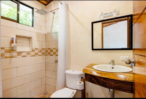 a bathroom with a sink and a toilet and a mirror at Apartamento el Guanacaste, cerca Tamarindo con Piscina in Santa Cruz