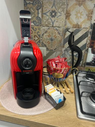 a red and black coffee maker on a counter at B&B Ladislaus in Ladispoli