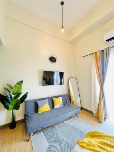 salon z kanapą i telewizorem w obiekcie 29 Chic Studio Escape w mieście Iloilo